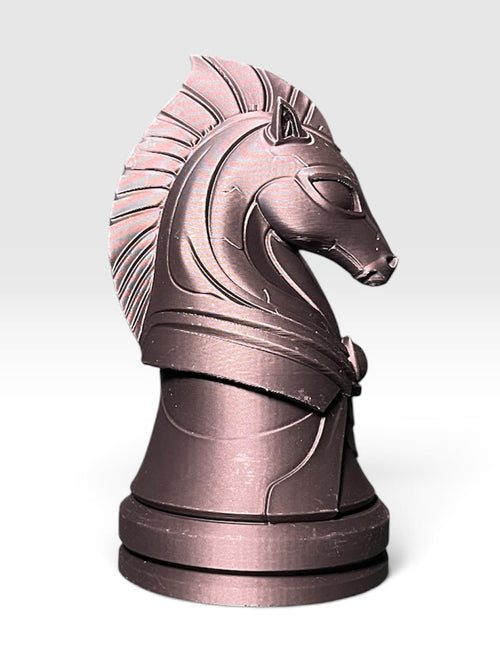 A knight chess piece statue shaped like a horse head with elongated, extraterrestrial features, standing on a round base against a white to light grey gradient background.