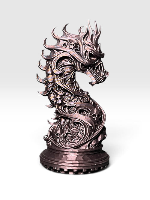 A knight chess piece statue shaped like a dragon-skull horse head with skull-laden detail, standing on a round base against a white to light grey gradient background.